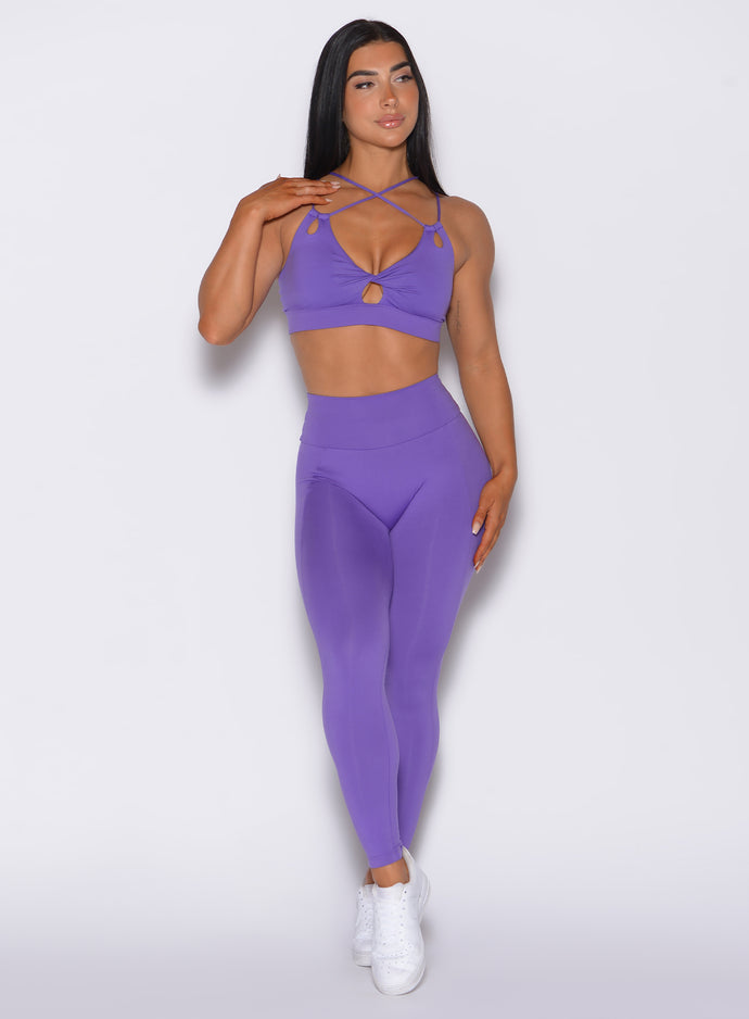 front profile view of a model wearing our shape leggings in royal purple color along with the matching bra