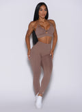 Front profile view of a model in our new and enhanced shape leggings in tan color and a matching bombshell sports bra