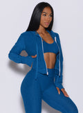 Right side profile view of a model angled slightly to her right wearing our signature jacket in azure color 