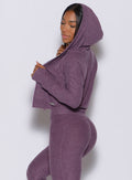 Left side profile view of a model in our signature jacket in  purple regal color and a matching leggings 