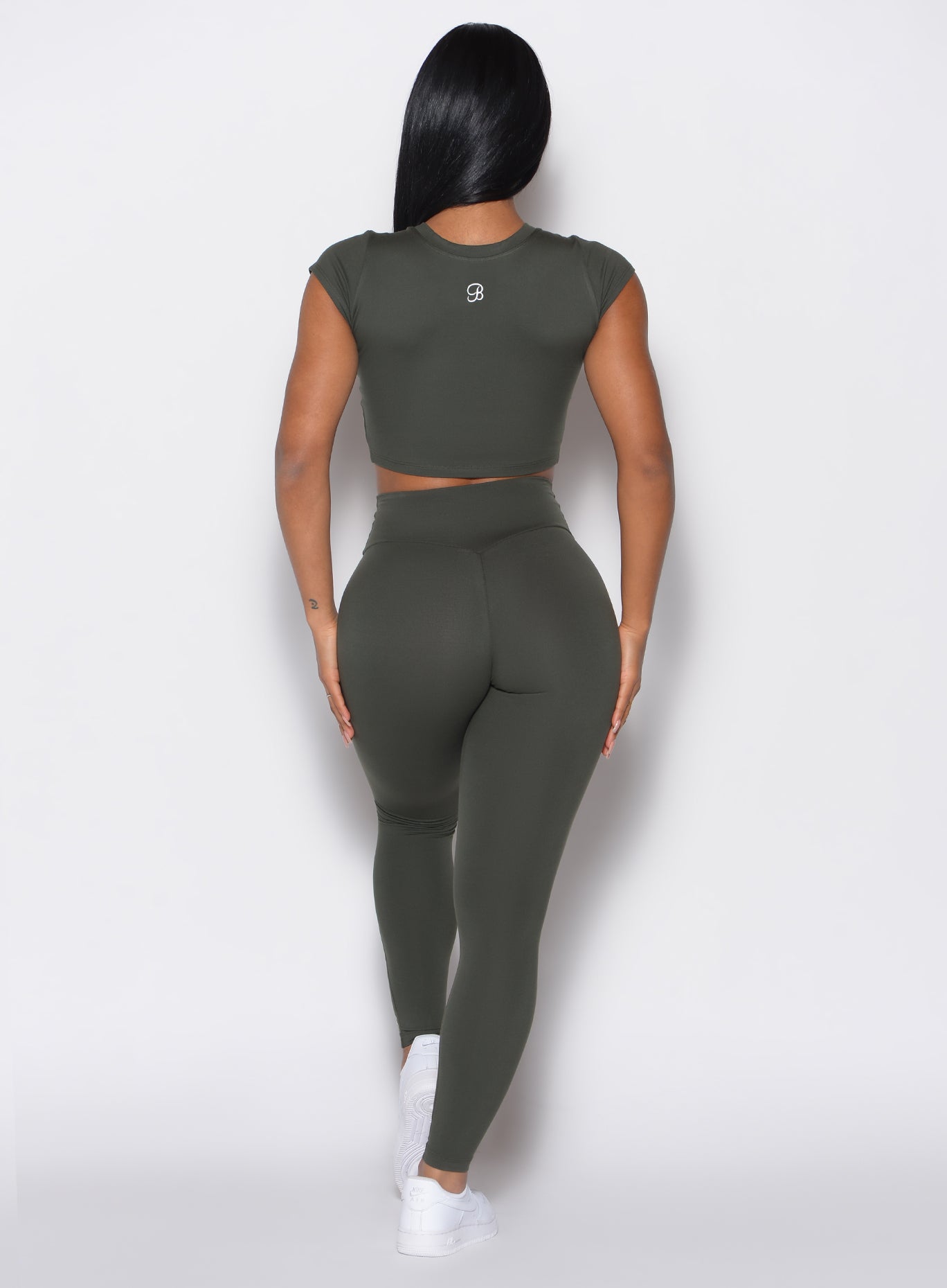 back profile of a model wearing the Smooth Leggings and the matching Tee in Deep Ivy color