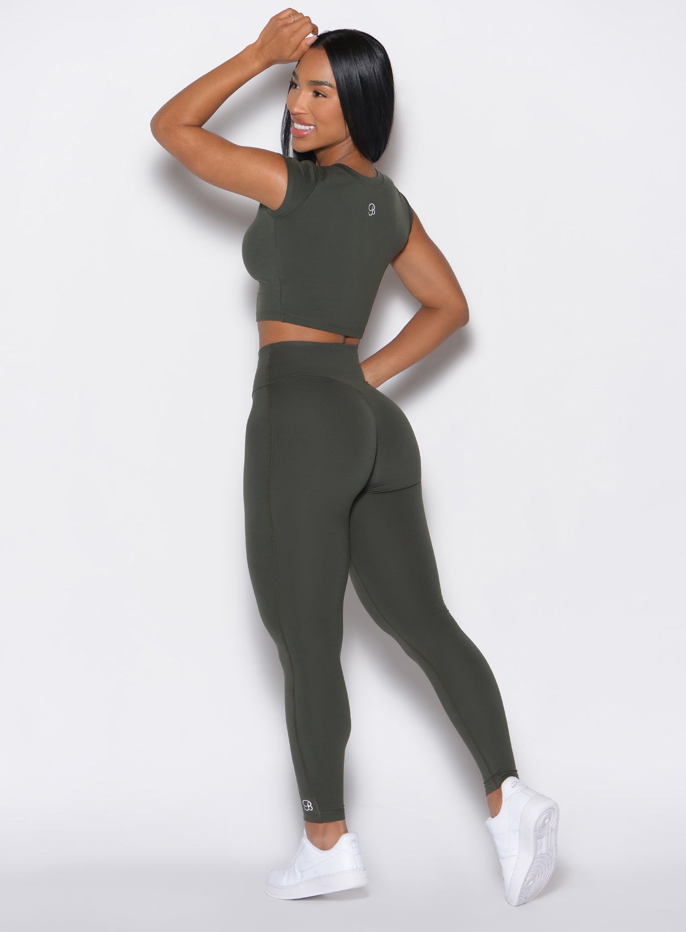 Left side view of model wearing the Smooth Leggings and the matching Tee in Deep Ivy color