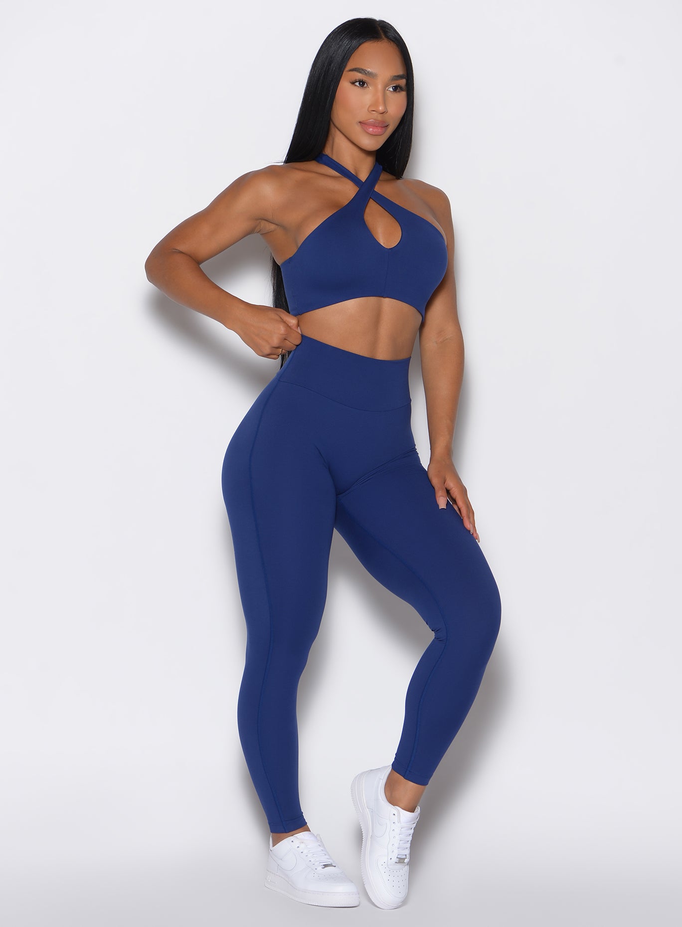  front profile view of a model angled slightly to her right wearing our Smooth Leggings and the matching bra in Royal Indigo color