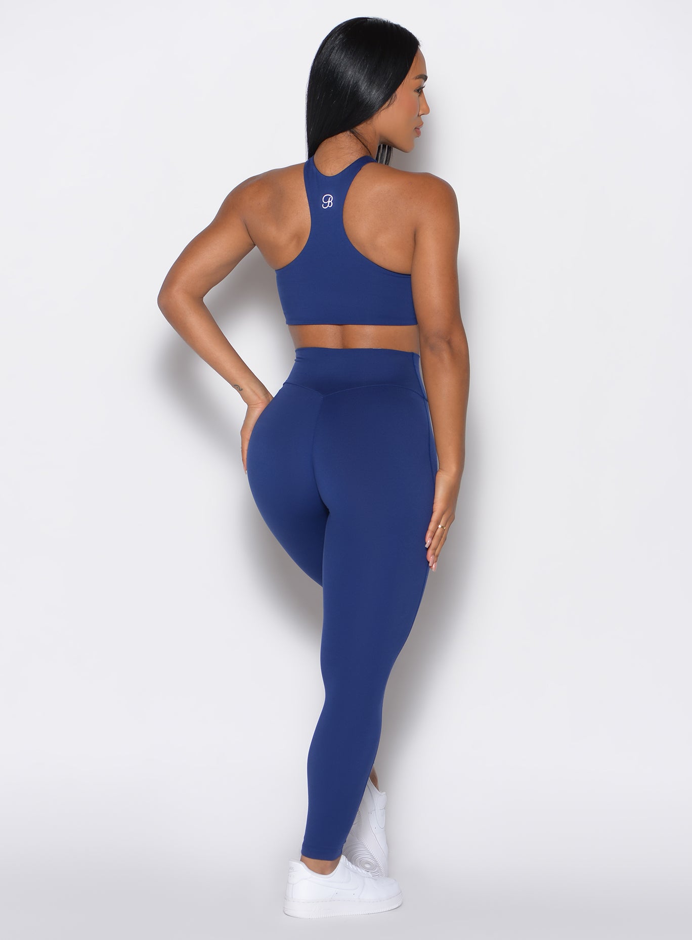 back profile of a model wearing the Smooth Leggings and the matching bra in Royal Indigo color