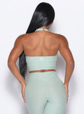 back profile view of our model wearing the Lift Halter Bra in soft aloe color