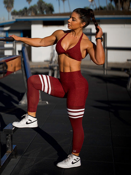 Front/left profile view of model posing in red bra and thigh high leggings set