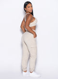 right side profile view of our model looking over her shoulder wearing the Sweat Joggers in Heathered Oatmeal color