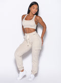 front profile view of our model wearing the Sweat Joggers in Heathered Oatmeal color paired with the matching bra