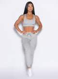 front profile view of our model with both hands on her waist wearing the Sweat Joggers in Light Heather grey color