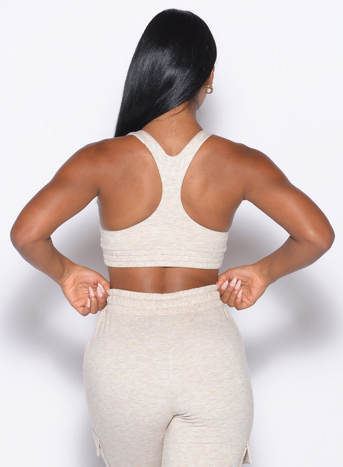 back profile view of our model adjusting the waistband of the joggers wearing the Sweat Lounge Bra in Heathered Oatmeal color