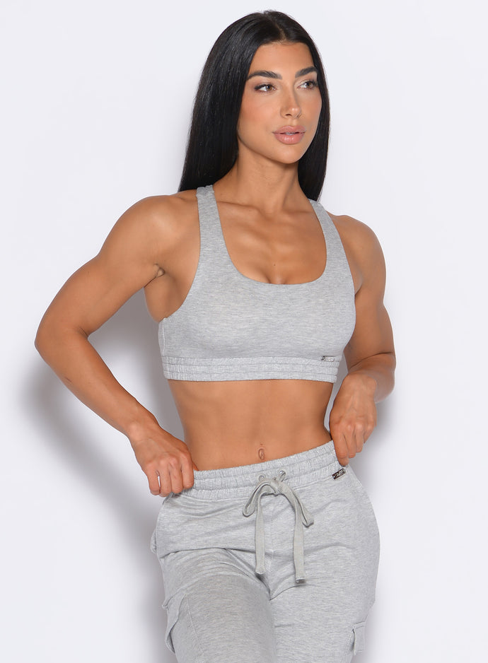 front profile view of our model adjusting the waistband of the joggers wearing the Sweat Lounge Bra in Light Heather Grey color