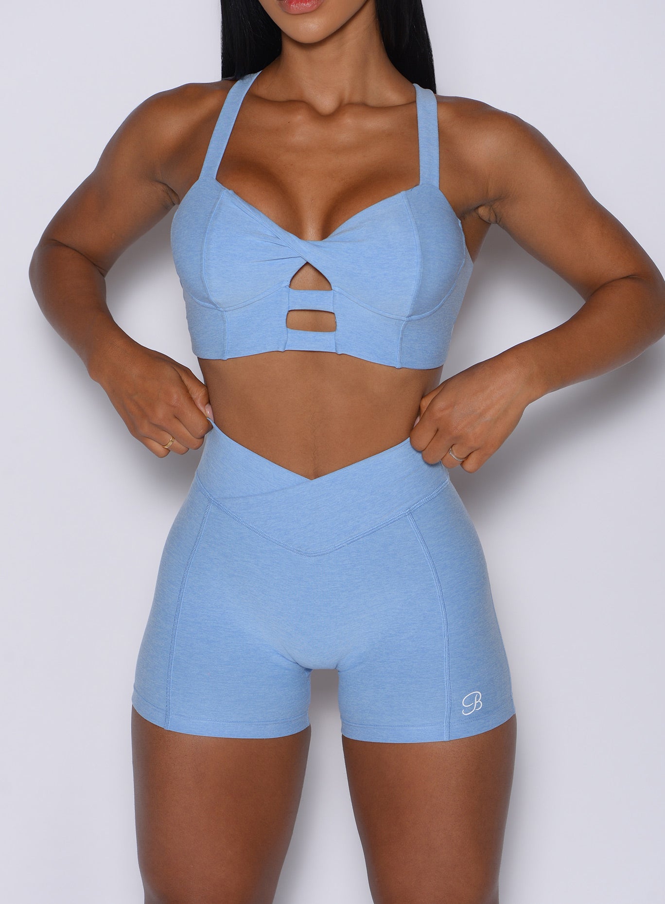 Model facing forward wearing our Tiny Waist Shorts in Bright Hydrangea color and a matching sports bra