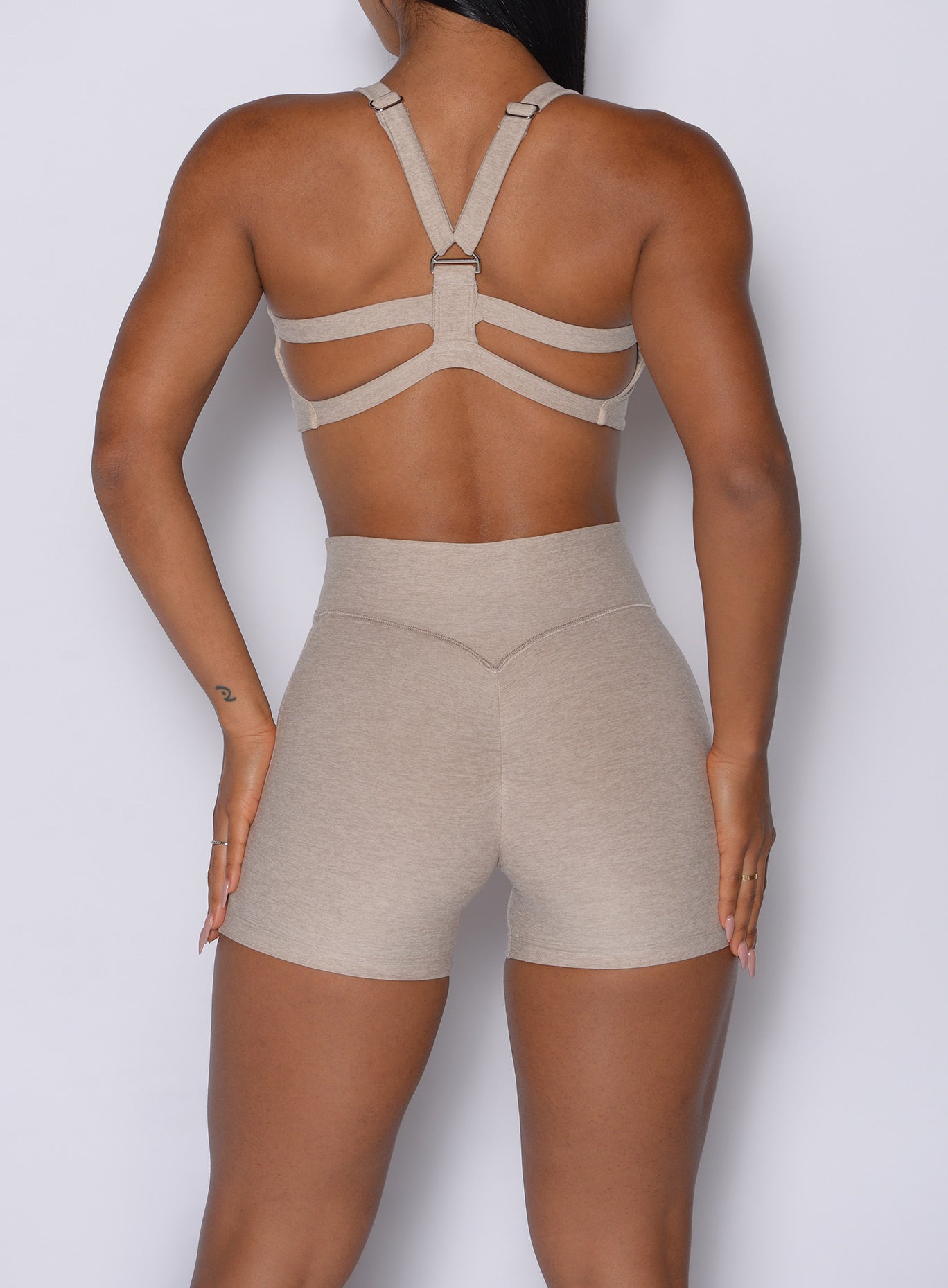Zoomed in back side view of our Tiny Waist Shorts in Taupe color and a matching sports bra
