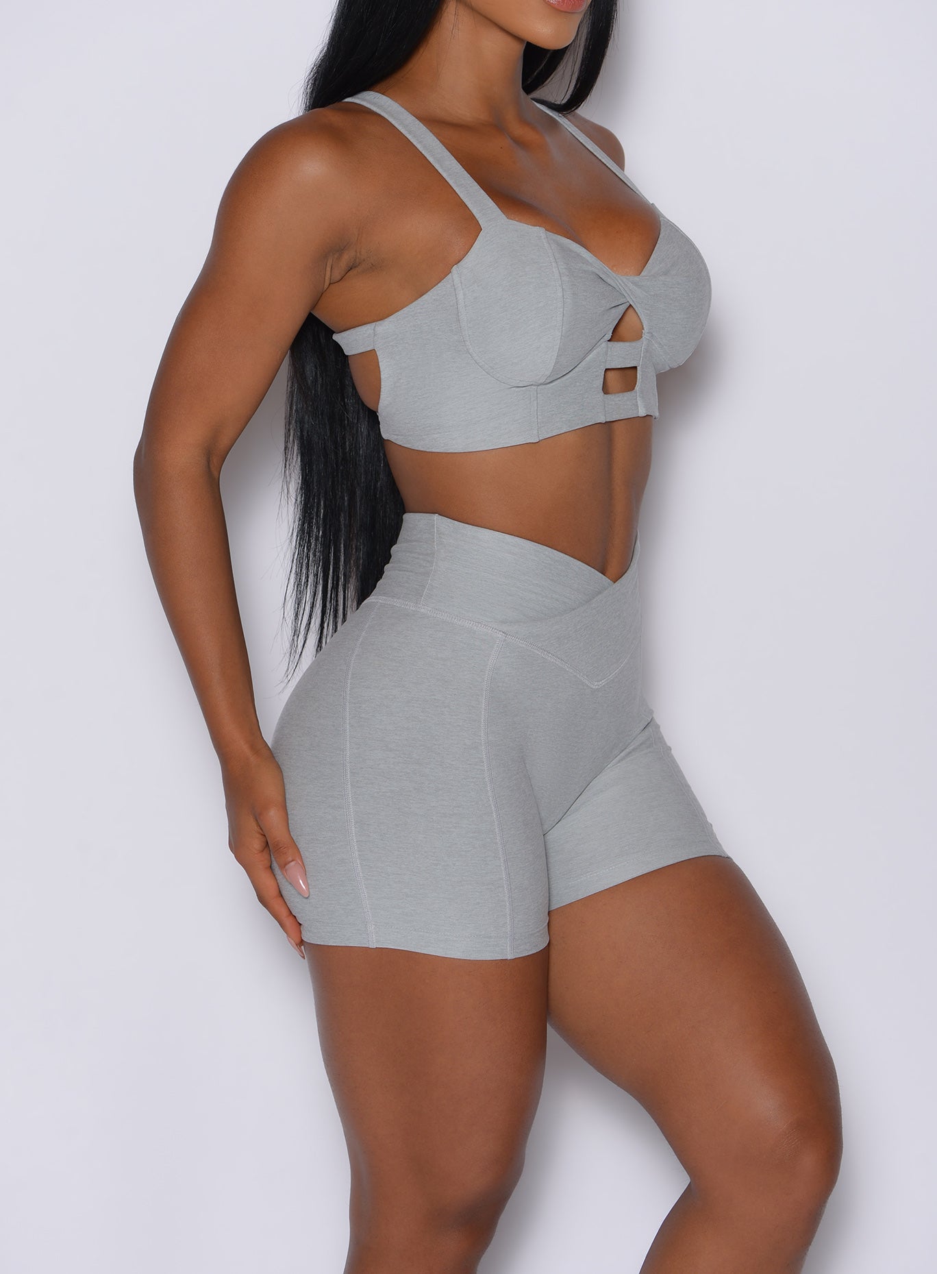zoomed in right side view of a model in our Tiny Waist Shorts in Light Cloud color and a matching sports bra