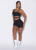 Model facing forward wearing our Tiny Waist Shorts and the matching Asymmetrical Slit Bra in Heathered Black color
