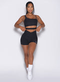 front profile view of a model wearing our Tiny Waist Shorts and the matching Asymmetrical Slit Bra in Heathered Black color