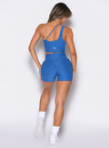 back profile of a model wearing the Tiny Waist Shorts and the matching Asymmetrical Slit Bra in Royal color