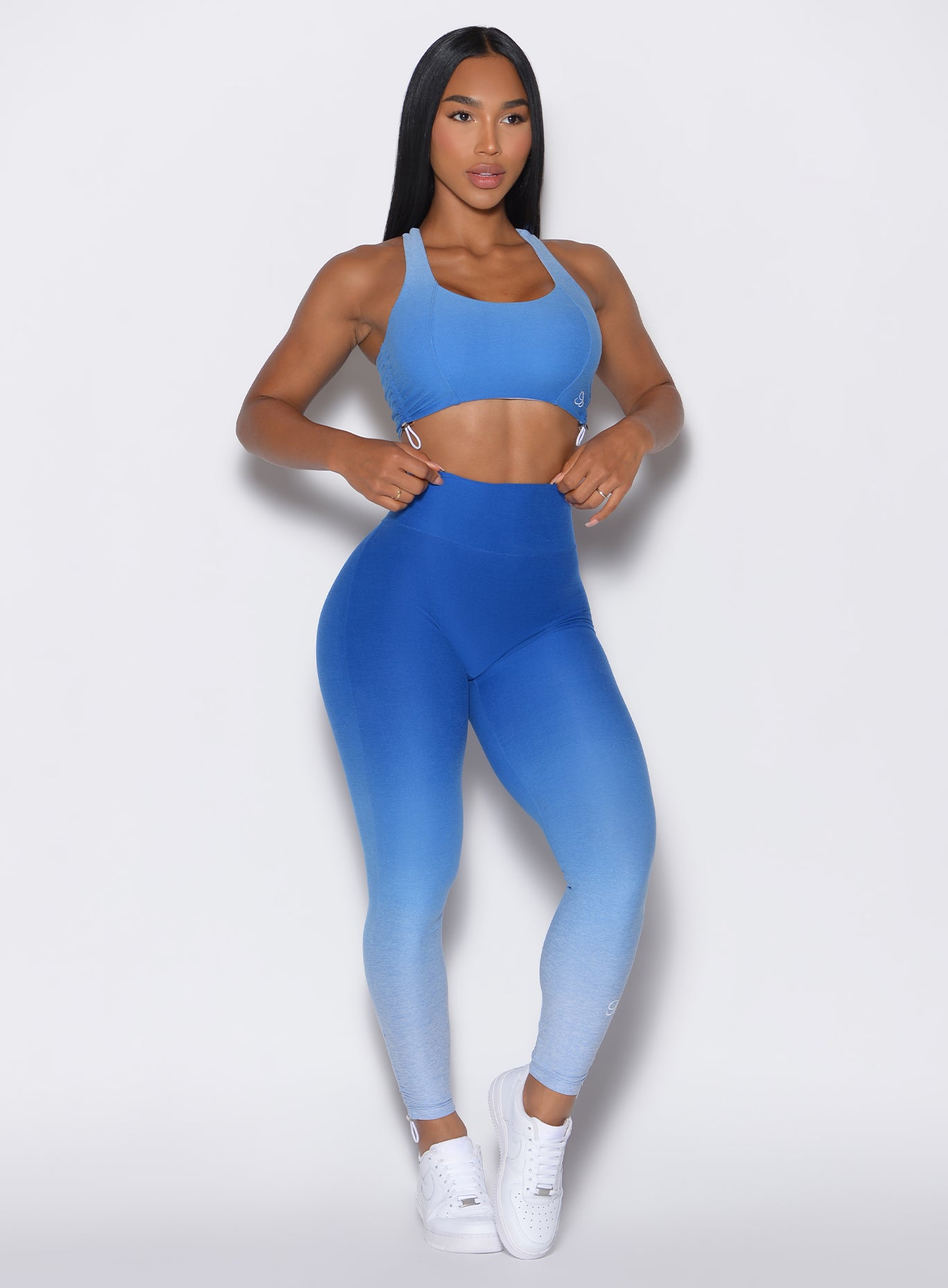 front profile picture  of a model wearing our toggle leggings in Ombre Blue Crush color along with the matching sports bra