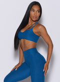 Left side profile picture of a model facing to her left wearing our topnotch bra in azure color and a matching leggings