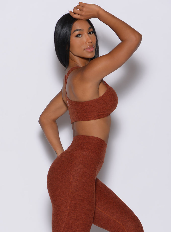 Right side profile view of a model facing to her right wearing our topnotchbra in cinnamon color along with the matching leggings 