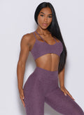 Front profile view of a model in our top notch bra in regal purple color along with the matching leggings