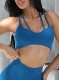 Front profile picture of a model facing to her right wearing our topnotch bra in azure color and a matching  leggings 