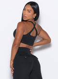 back left side profile view of our model looking over her shoulder wearing the Two Way Bra in Black color