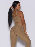 Back  profile picture of a model in our two way sports bra in caramel color and a matching leggings