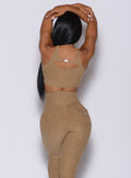 Back profile picture of a model in our two way sports bra in caramel color and a matching leggings