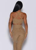 Back profile view of a model wearing our two way sports bra in caramel color and a matching high waisted leggings