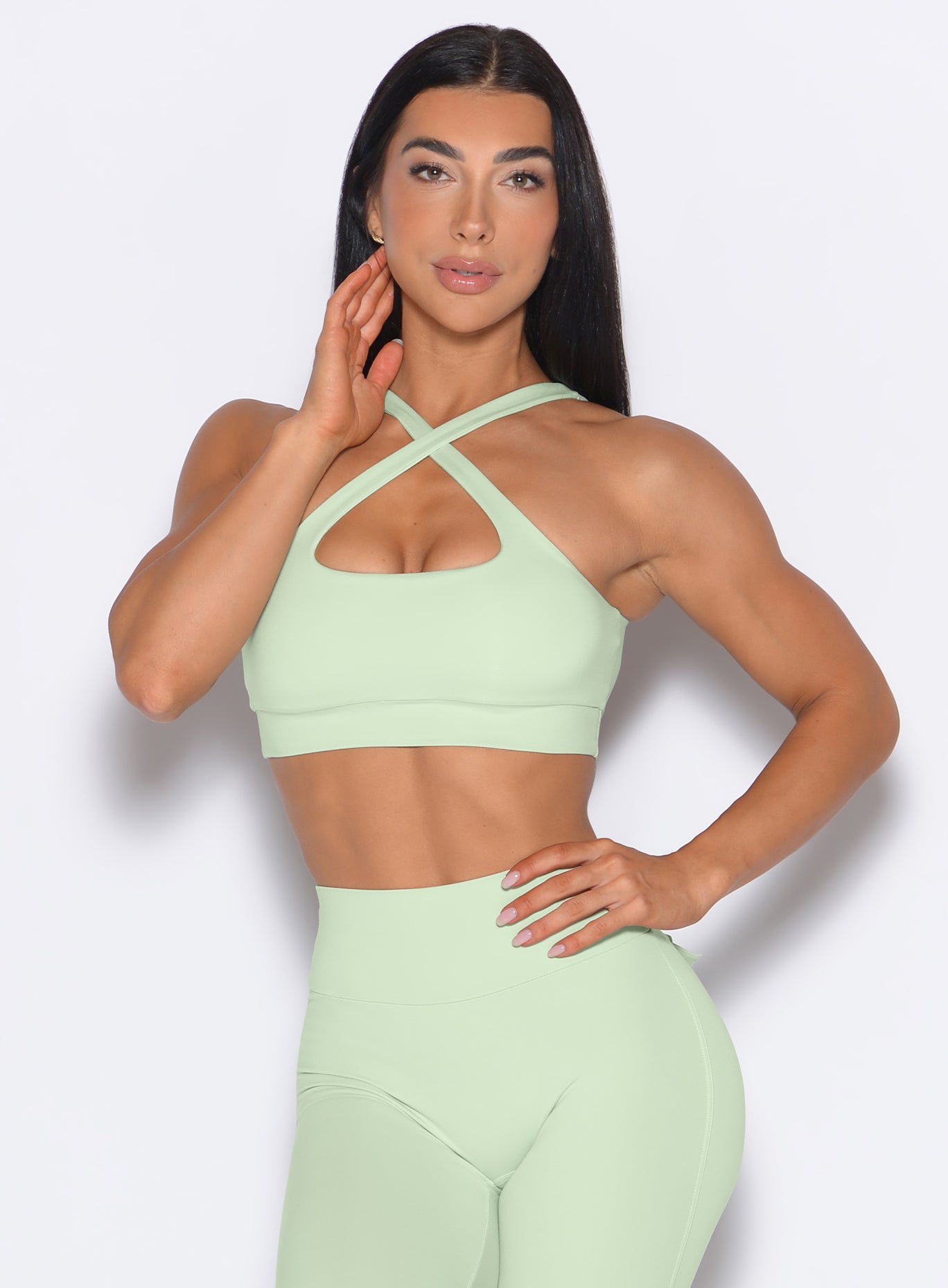 front profile view of a model wearing our Two Way Bra in Cool Matcha color and a matching leggings 