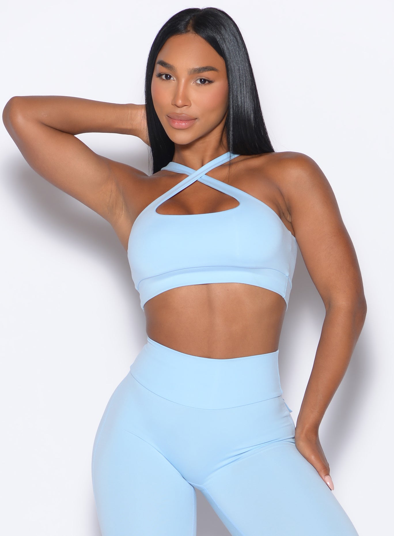 front profile view of a model wearing our Two Way Bra in Glacial Blue color and a matching leggings 
