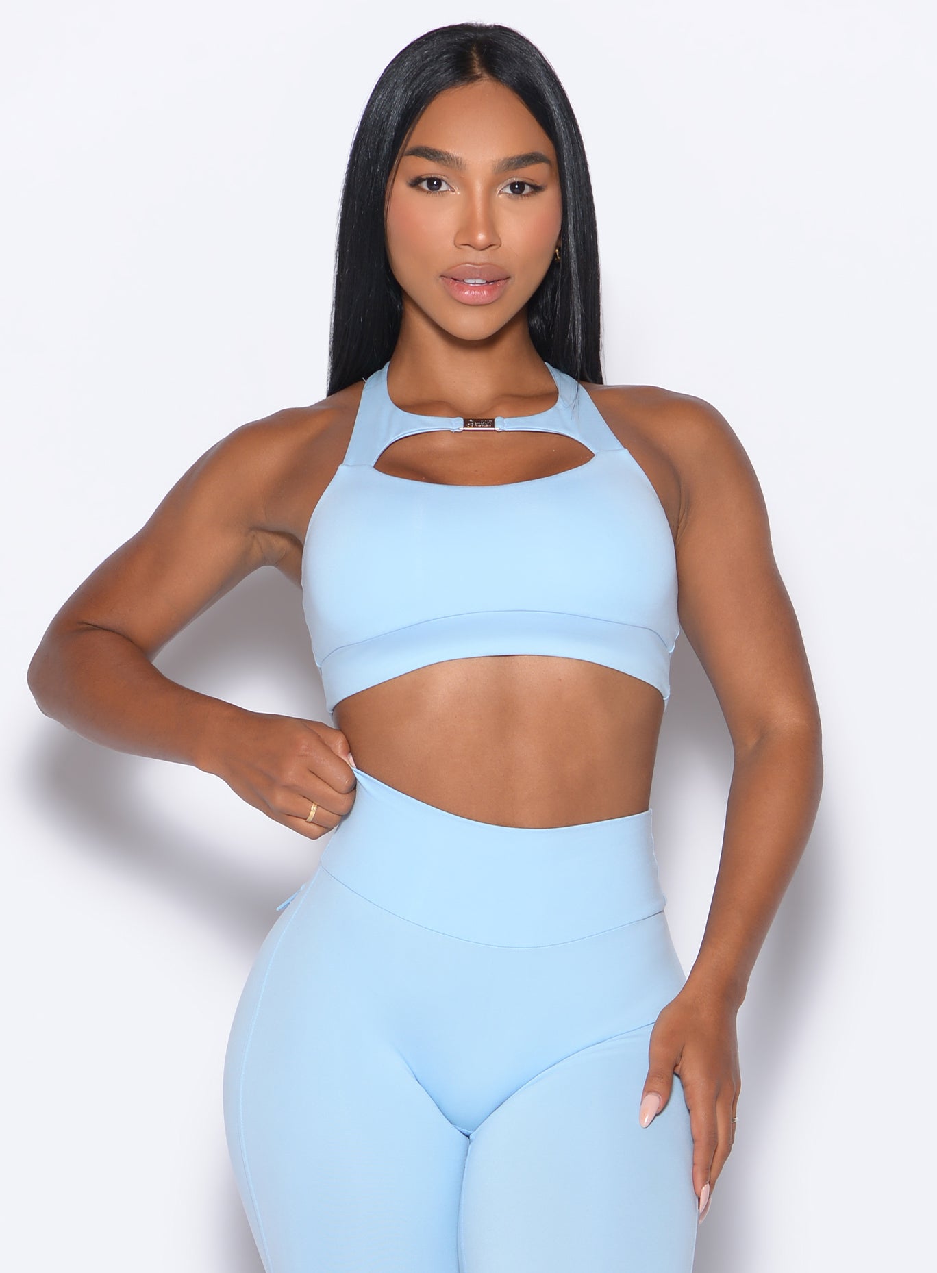 Model facing forward wearing our Two Way Bra in Glacial Blue color and a matching leggings 
