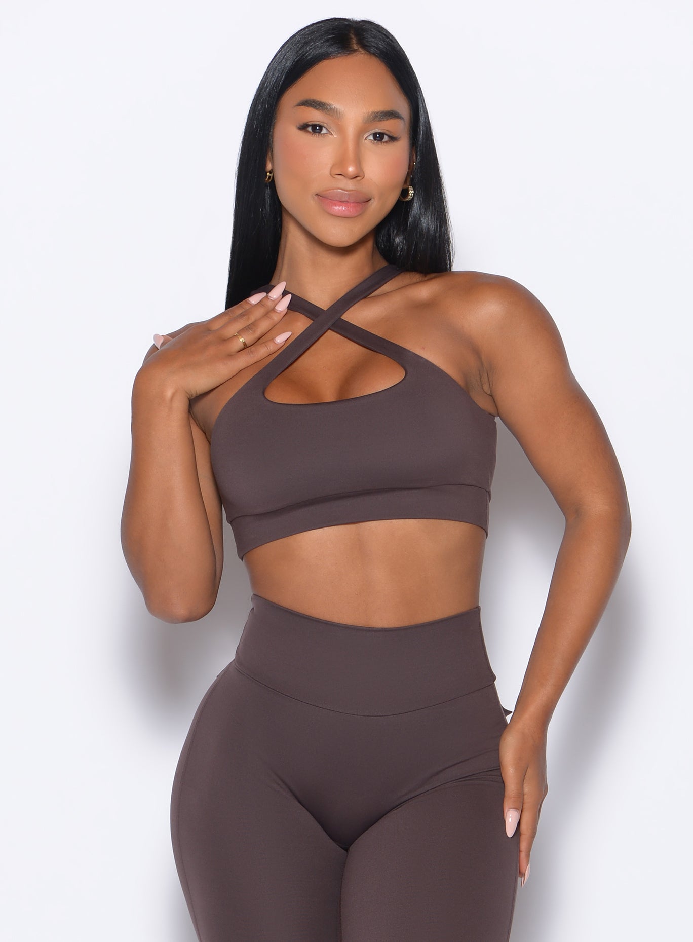 front profile view of a model wearing our Two Way Bra in Seal Brown color and a matching leggings 