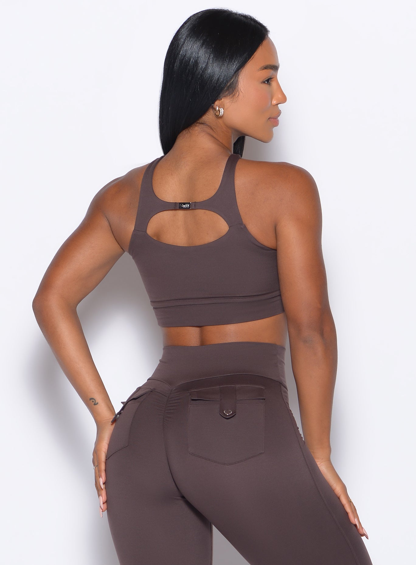 Back side close up view of model wearing the Two Way Bra in Seal Brown color and a matching leggings 
