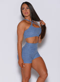 Right side profile view of a model facing to her right wearing our two way bra in sky blue color and a matching high waisted shorts