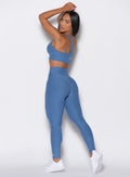 left side view of a model facing to her left wearing our V Active Leggings and the matching Top in Chambray color