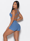 left side view of a model facing to her left wearing our V Active Shorts and the matching bra in Chambray color