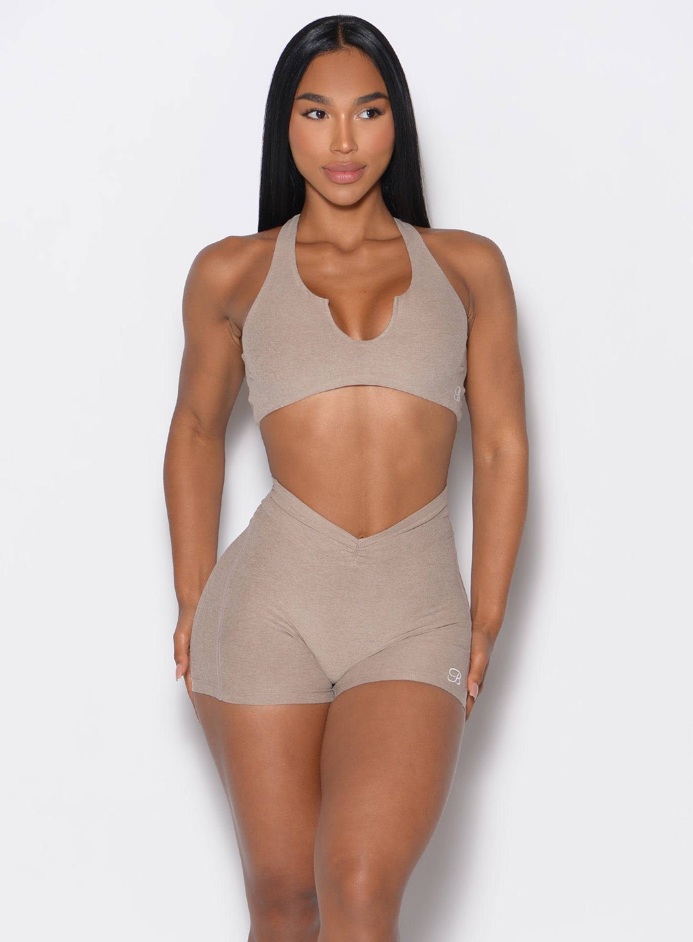  front profile view of a model wearing out V Active Shorts and the matching bra in Desert Taupe color