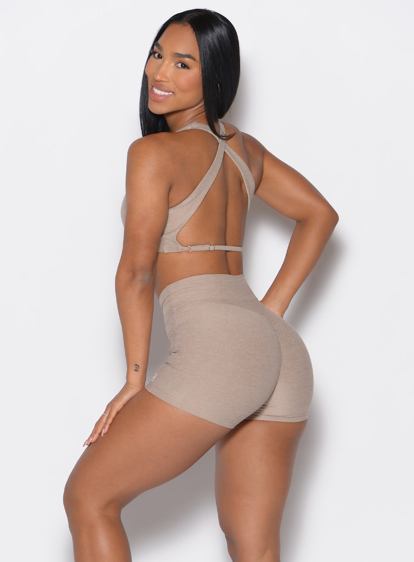 back profile of a model wearing the V Active Shorts and the matching bra in Desert Taupe color