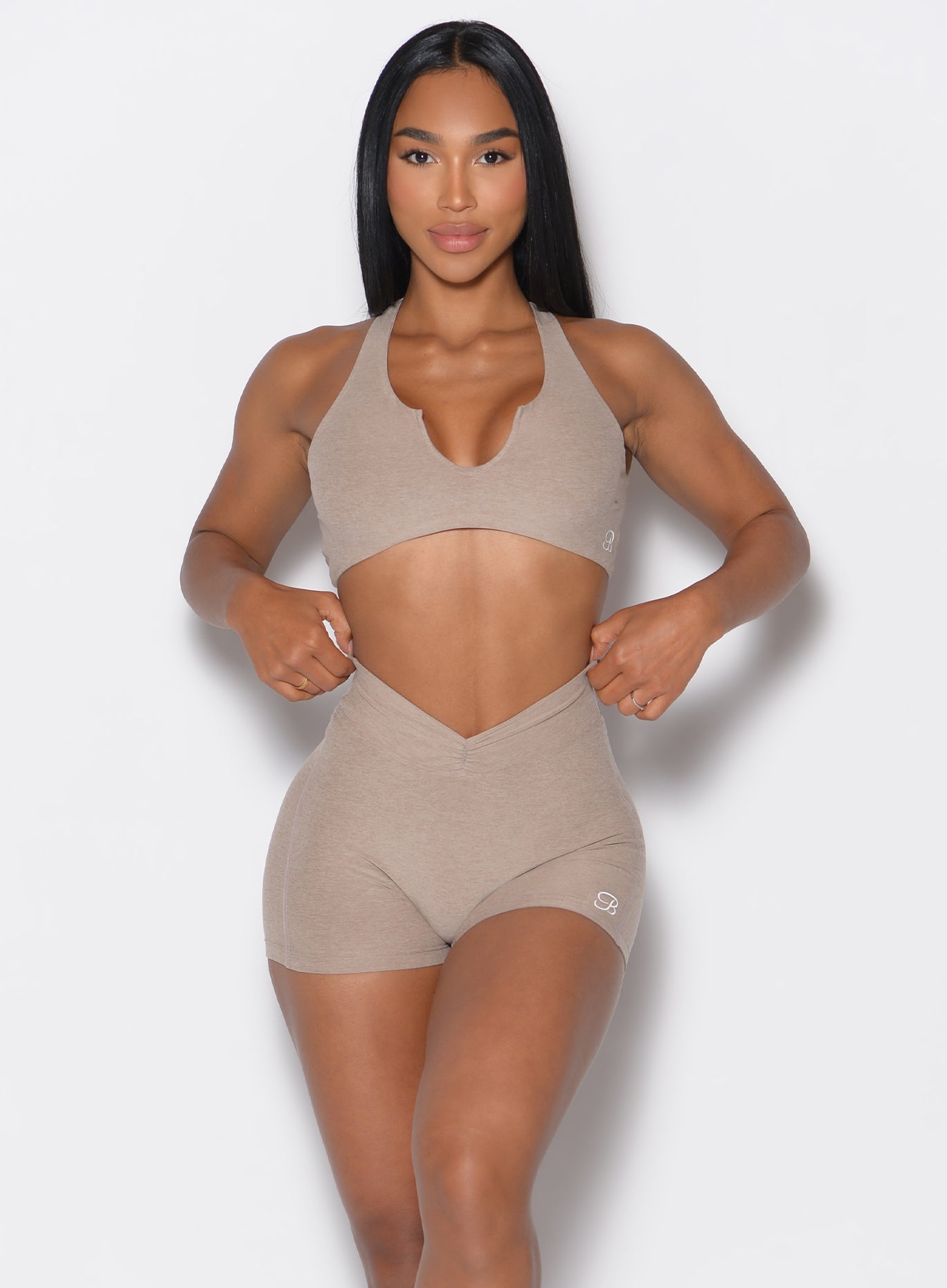 Model facing forward wearing our V Active Shorts and the matching bra in Desert Taupe color