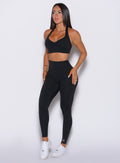 side profile picture of a model wearing our black V back leggings and the matching bra 