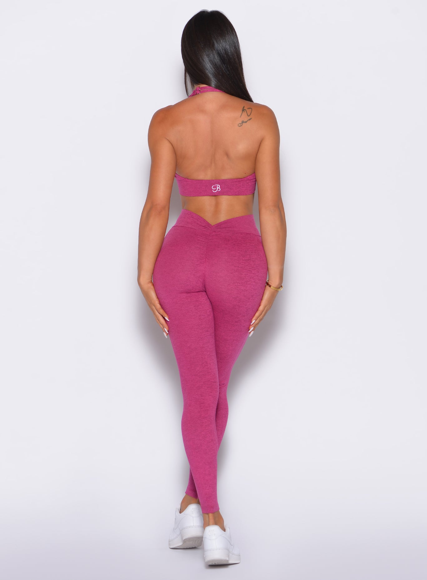 back shot of model smiling wearing the v back leggings