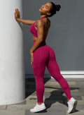 Side profile of model holding the wall outside wearing our v back leggings set