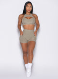 front profile view of a model looking to the left with both hands inside the pockets wearing the V Back Shorts in toasted Sugar color