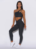 front profile view of a model facing forward wearing our V Active Leggings in charcoal color along with the matching top