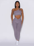 front profile view of a model wearing our V Active Leggings in lilac gray color along with the matching top