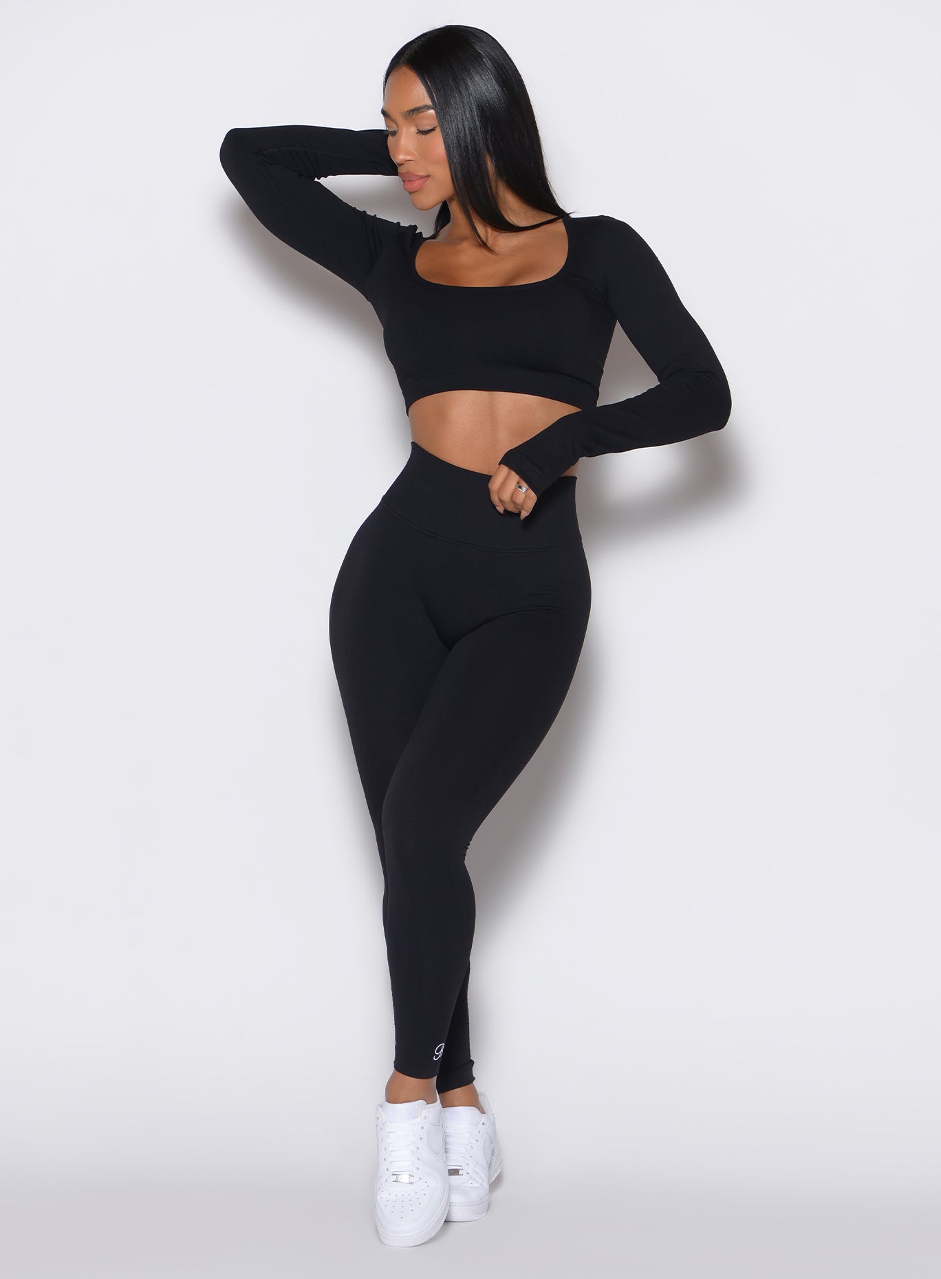 front profile picture of a model wearing our black V Seamless Leggings along with a matching pullover