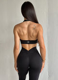 Back profile view of a model in our black backless bra along with the matching leggings 