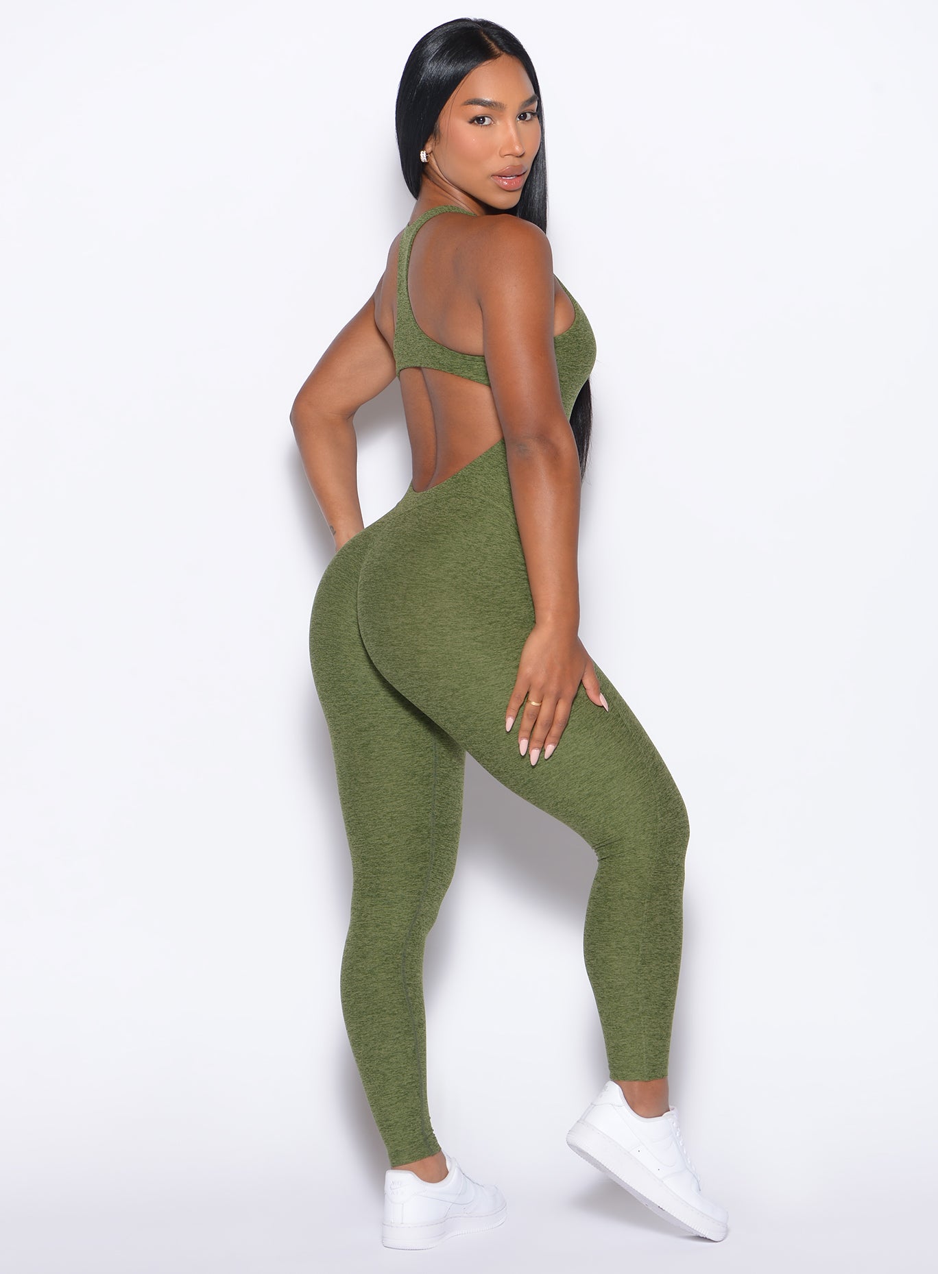 Right side profile view of our model looking over her shoulder wearing the Athletic Bodysuit in Juniper color